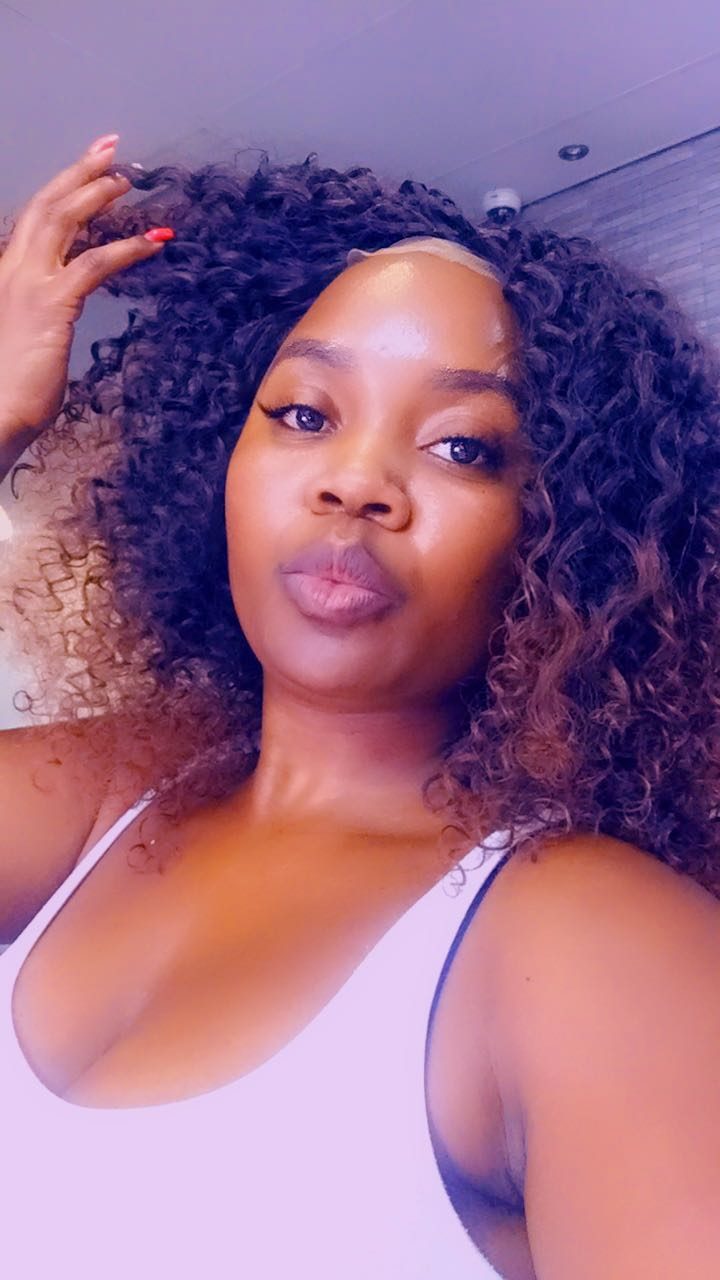 Client wearing a dark curly wig
