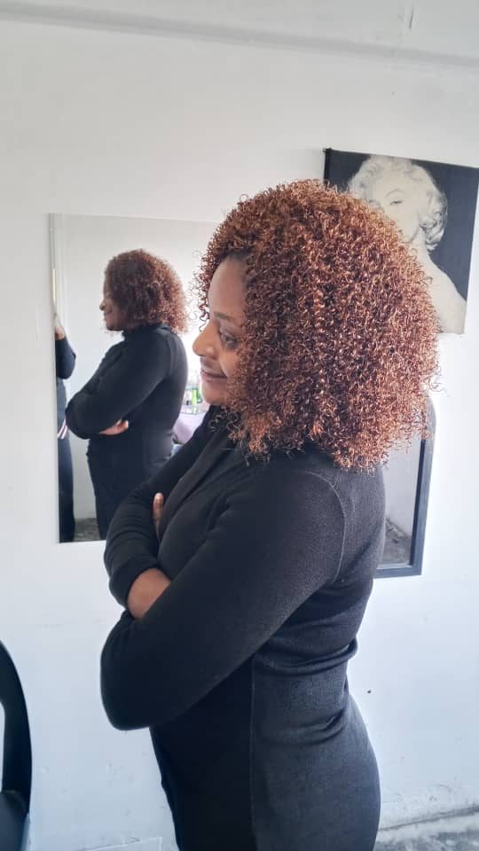 Client styled in a reddish curly wig