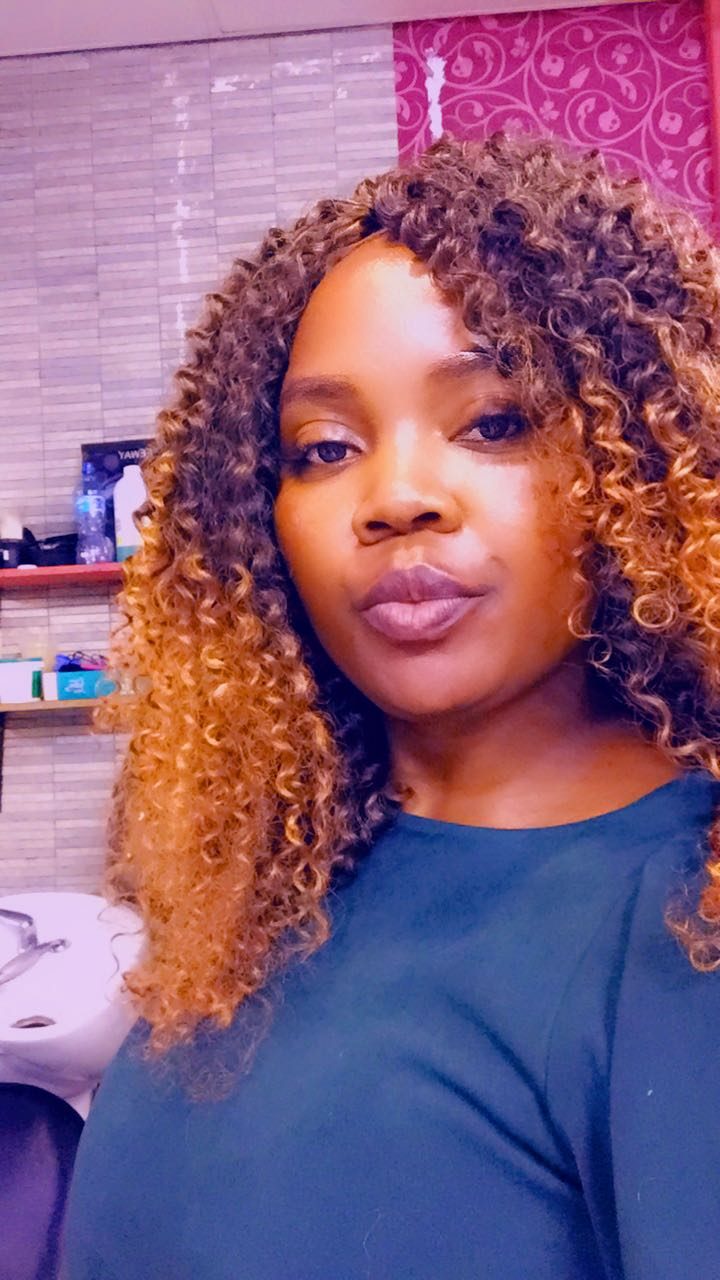 Client wearing a honey-blonde curly wig